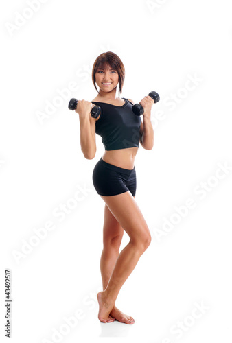 A young and fit brunette woman holding dumbbells