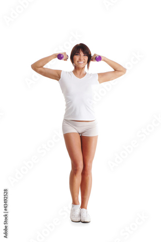 A young and fit Caucasian woman training with dumbbells