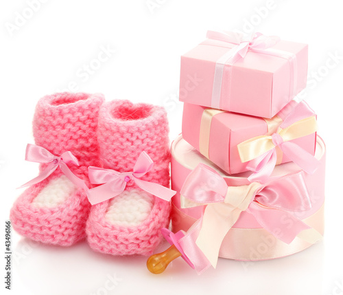 pink baby boots, pacifier and gifts isolated on white