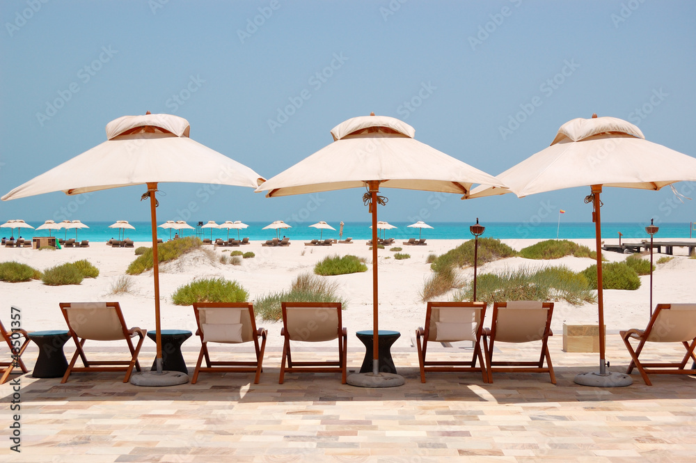 Sunbeds and umbrellas at the Beach of luxury hotel, Abu Dhabi, U