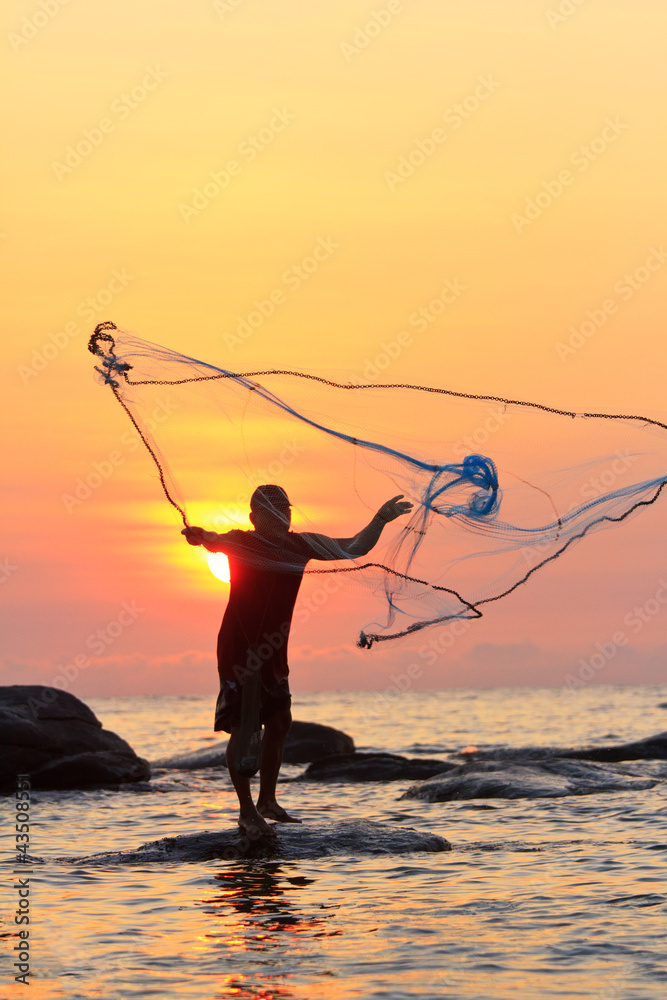 throwing fishing net during sunrise, Thailand Stock Photo