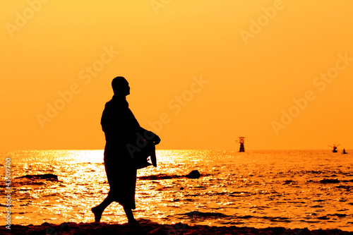 Silhouettes of monks on the beach,Hua Hin Thailand
