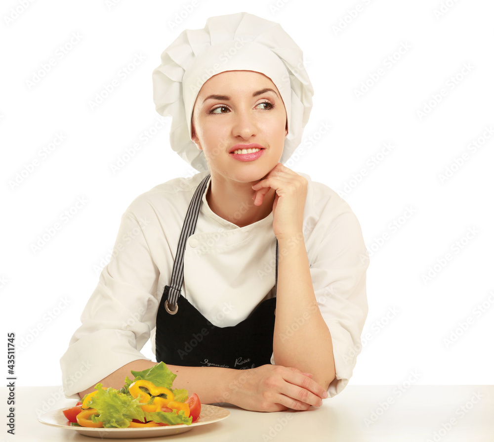 Pretty cook chief sitting on the table with salad Pretty cook chief sitting on the table with salad