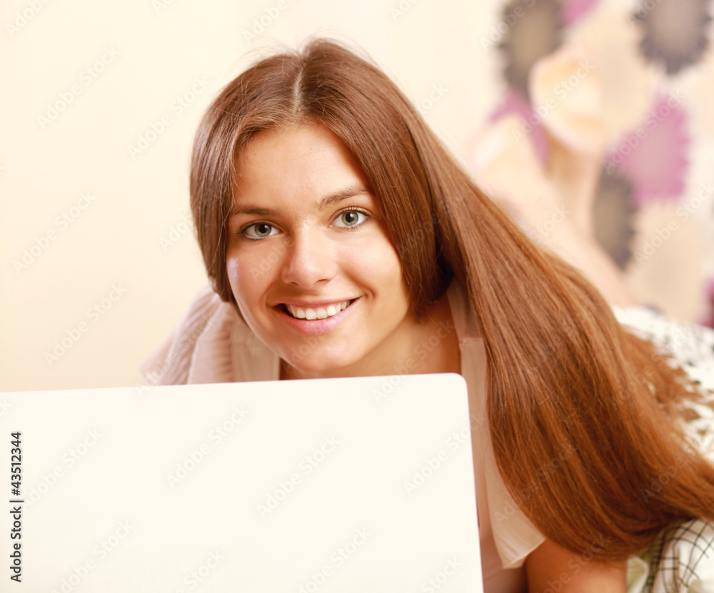 A young woman lying on the bed with laptop A young woman lying on the bed with laptop