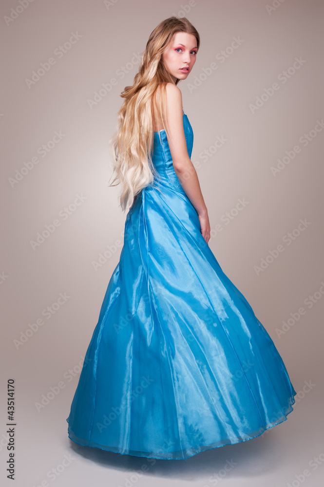 Beautiful young woman wearing a sexy blue evening dress Beautiful young woman wearing a sexy blue evening dress