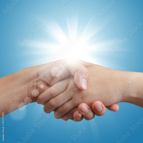 handshake on blue sky and sunlight