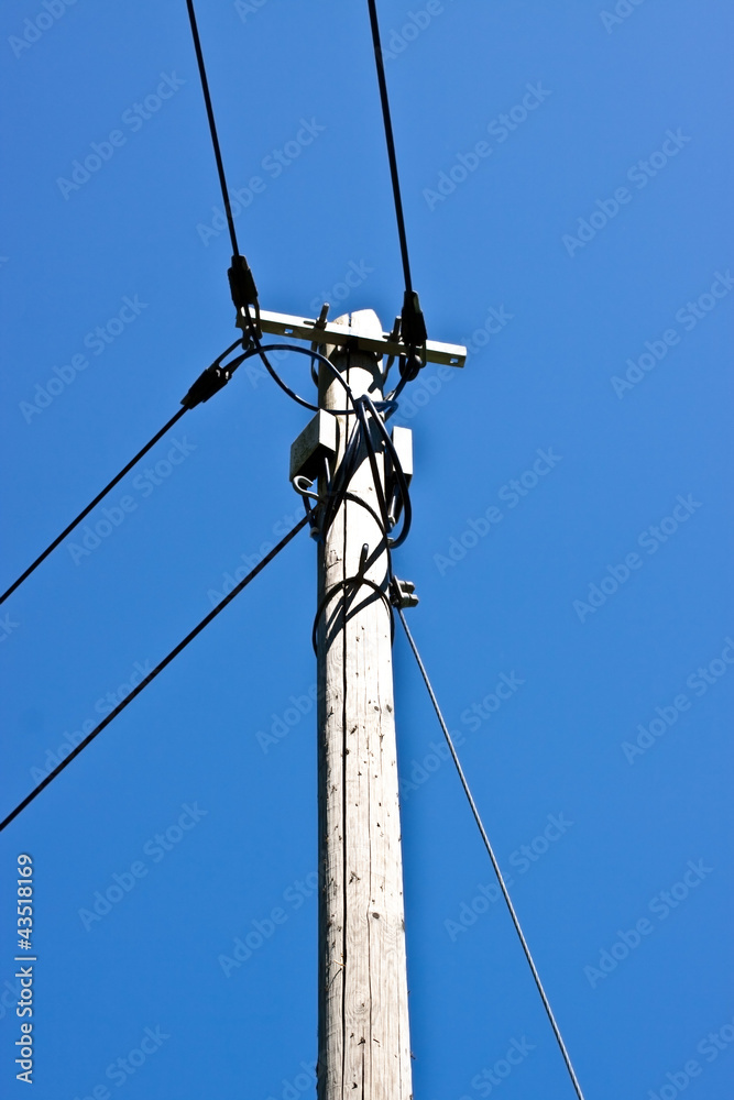 Alter Telefonmast vor blauem Himmel