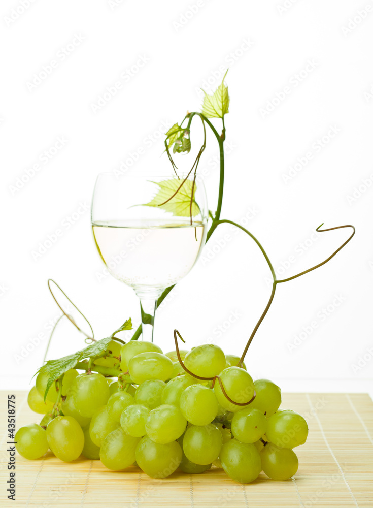 Grapevine, branch of green grapes and glass of white wine Grapevine, branch of green grapes and glass of white wine