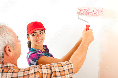 Senior man teaching how to paint a wall