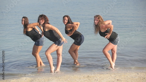 Group of four beautiful women dancing in the water