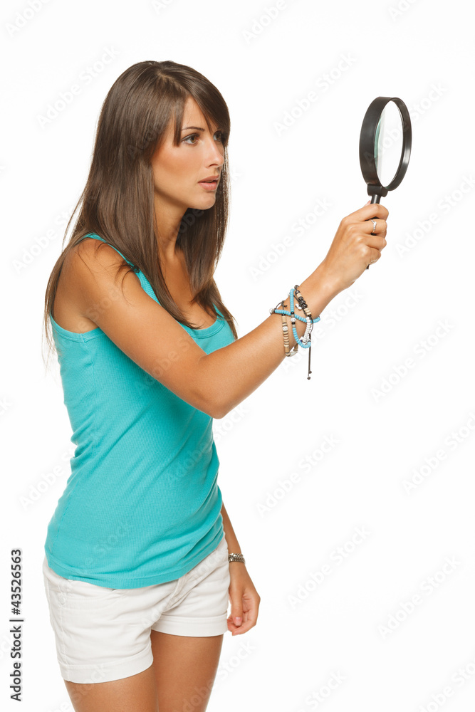 Serious female looking through the magnifying glass Serious female looking through the magnifying glass