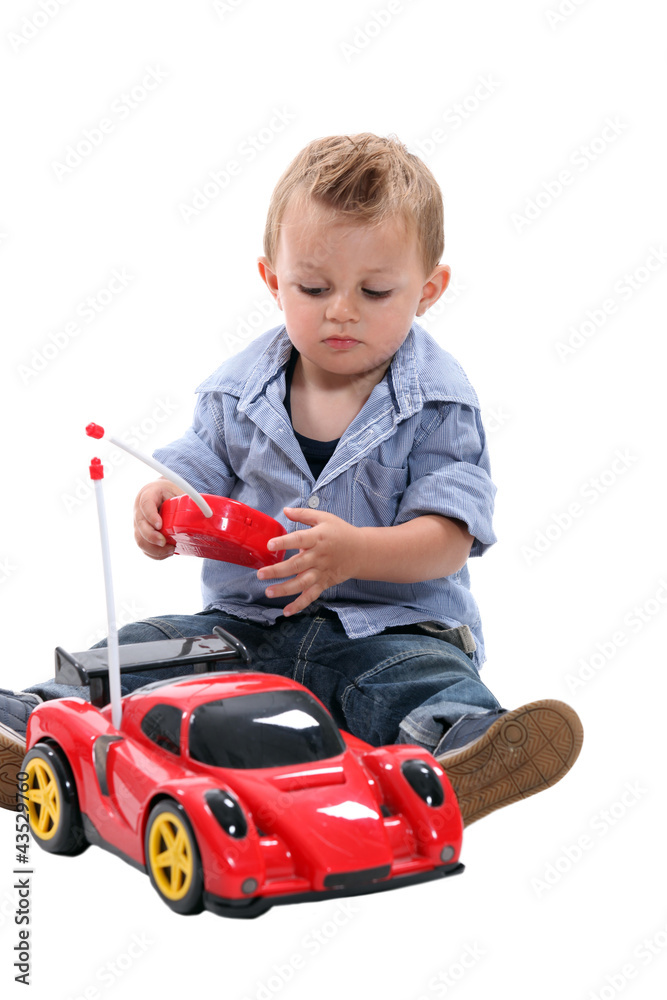 Cute little boy playing with a remote controlled car. Cute little boy playing with a remote controlled car.