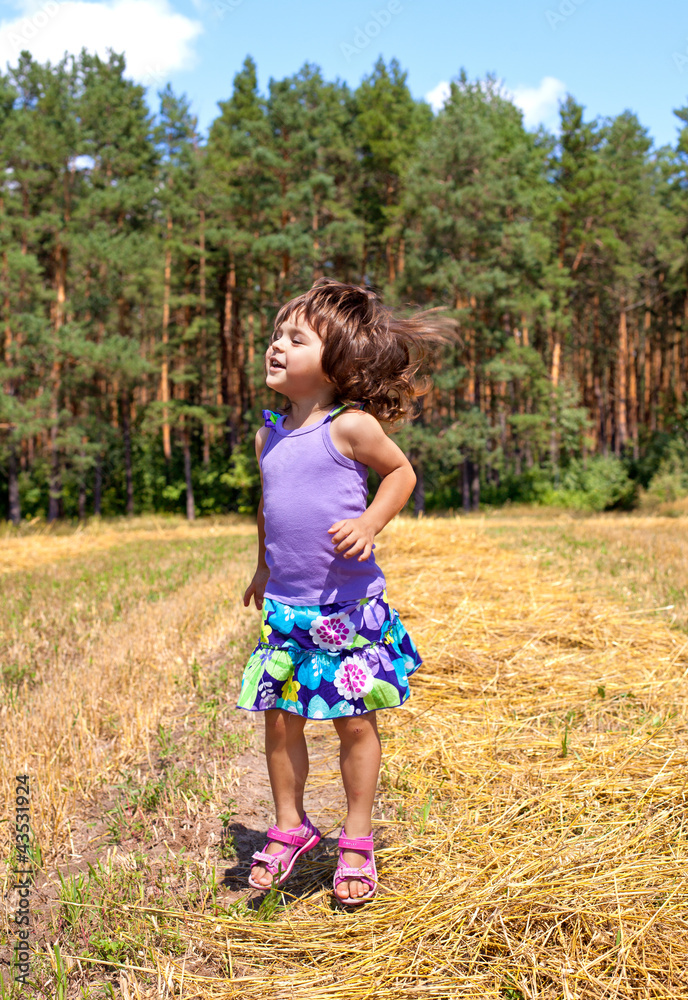 Little girl jumping in a meadow Little girl jumping in a meadow