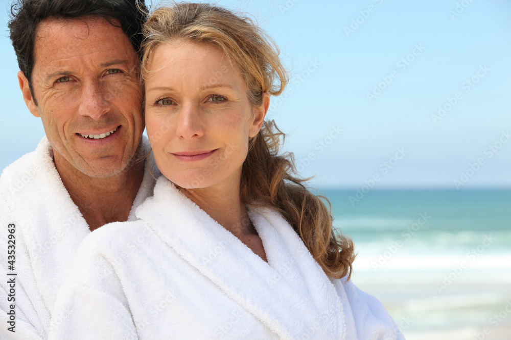 Couple in bathrobes on the beach Couple in bathrobes on the beach