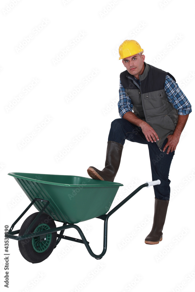 Man resting foot on wheelbarrow Man resting foot on wheelbarrow