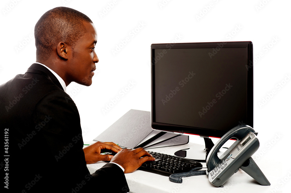 Male executive typing and looking at lcd screen Male executive typing and looking at lcd screen