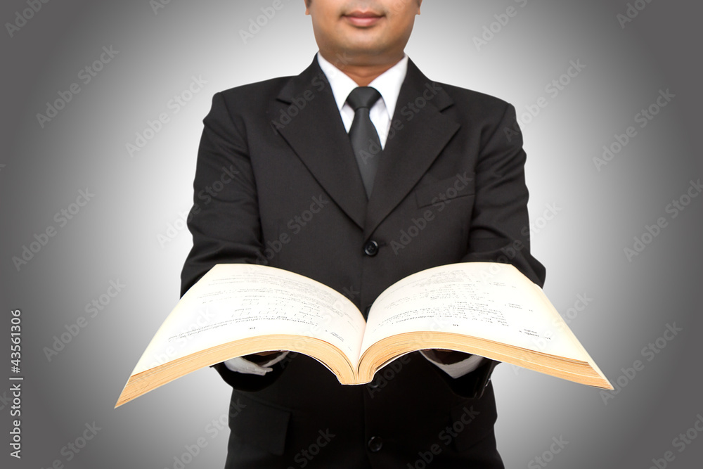 Businessman or teacher reading from a book