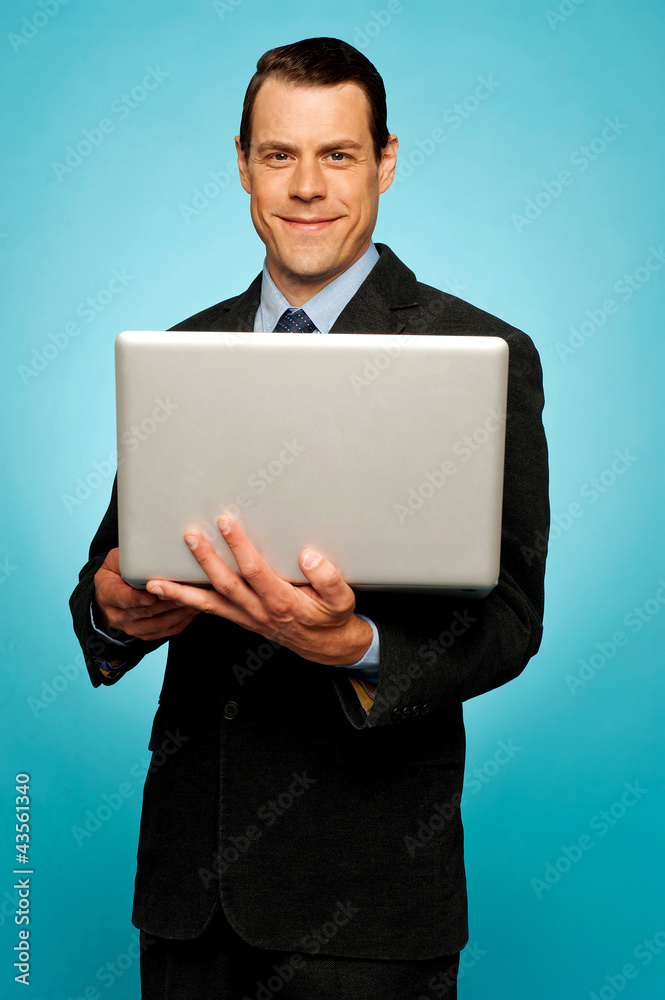 Attractive businessman holding laptop Attractive businessman holding laptop