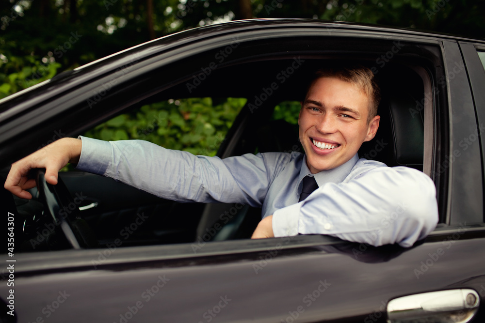 Young man sitting in the car smiling Young man sitting in the car smiling