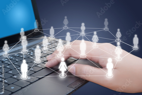 Hand pushing laptop keyboard with Social Network.