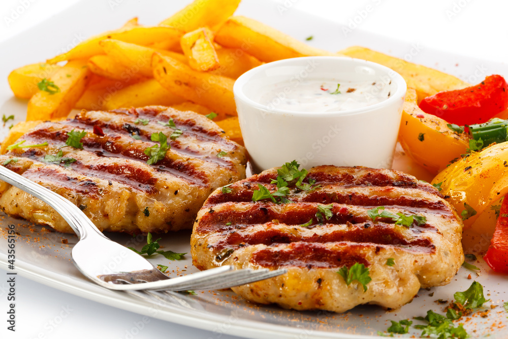 Grilled steaks, French fries and vegetables Grilled steaks, French fries and vegetables