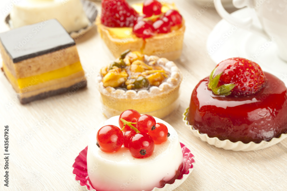 Different sort of beautiful pastry, small colorful sweet cakes