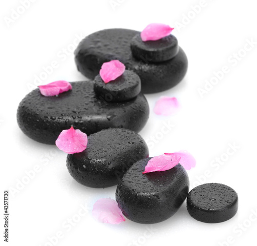 Spa stones with drops and pink petals isolated on white.