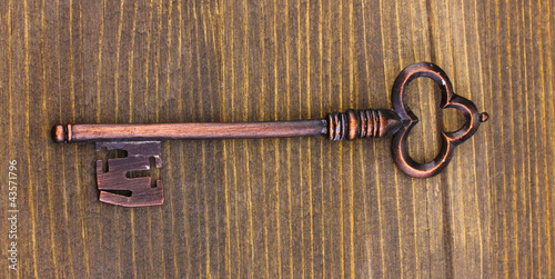 Antique key on wooden background