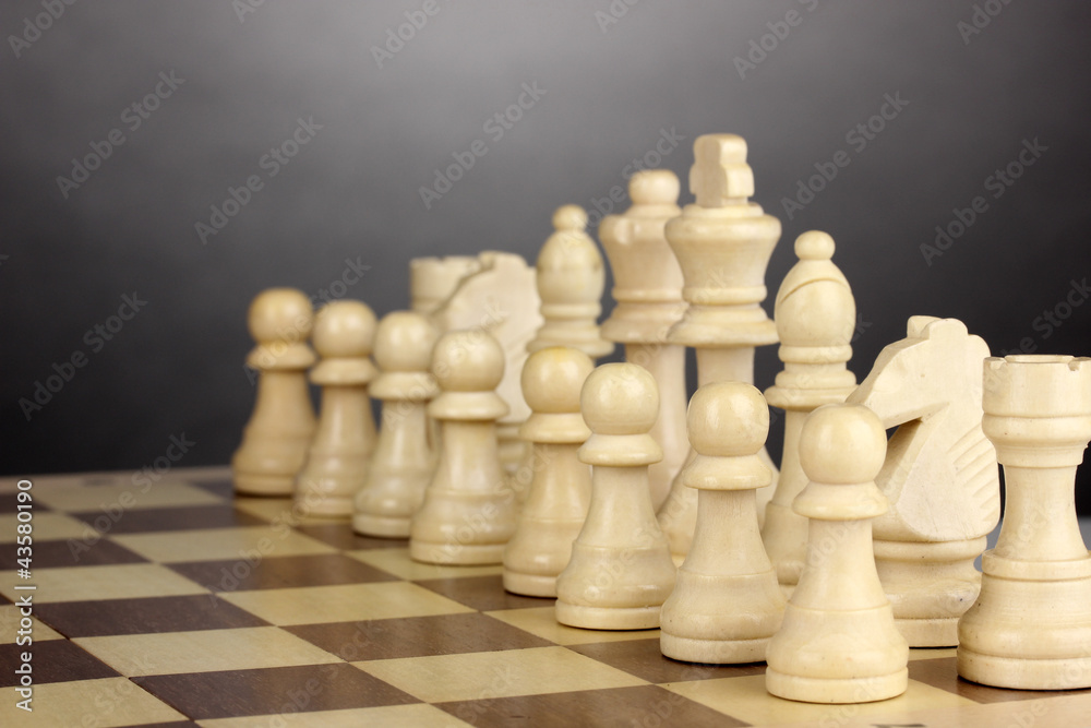 Chess board with chess pieces on grey background Chess board with chess pieces on grey background