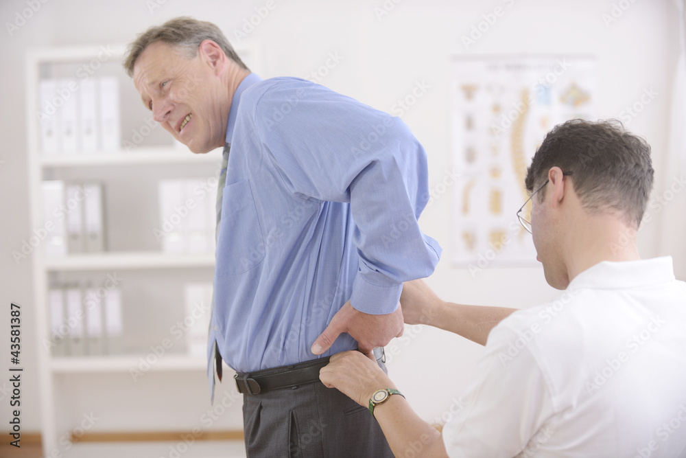 Obraz premium Chiropractic: Chiropractor examining senior man