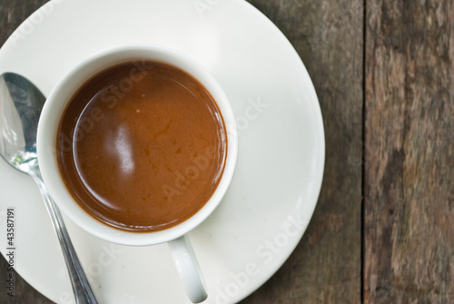 Coffee cup on the wood texture background.