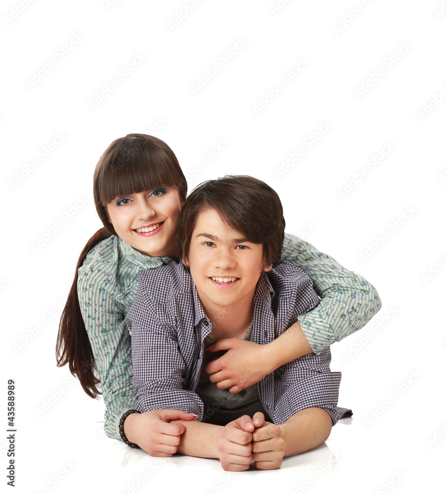 A young couple lying on the floor, isolated on white background A young couple lying on the floor, isolated on white background