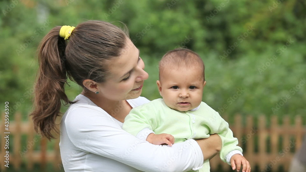 Beautiful young mother holding her happy small son at summer Beautiful young mother holding her happy small son at summer