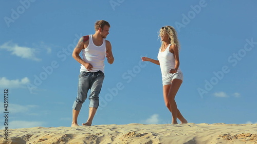 Happy slim couple dancing at the beach  together