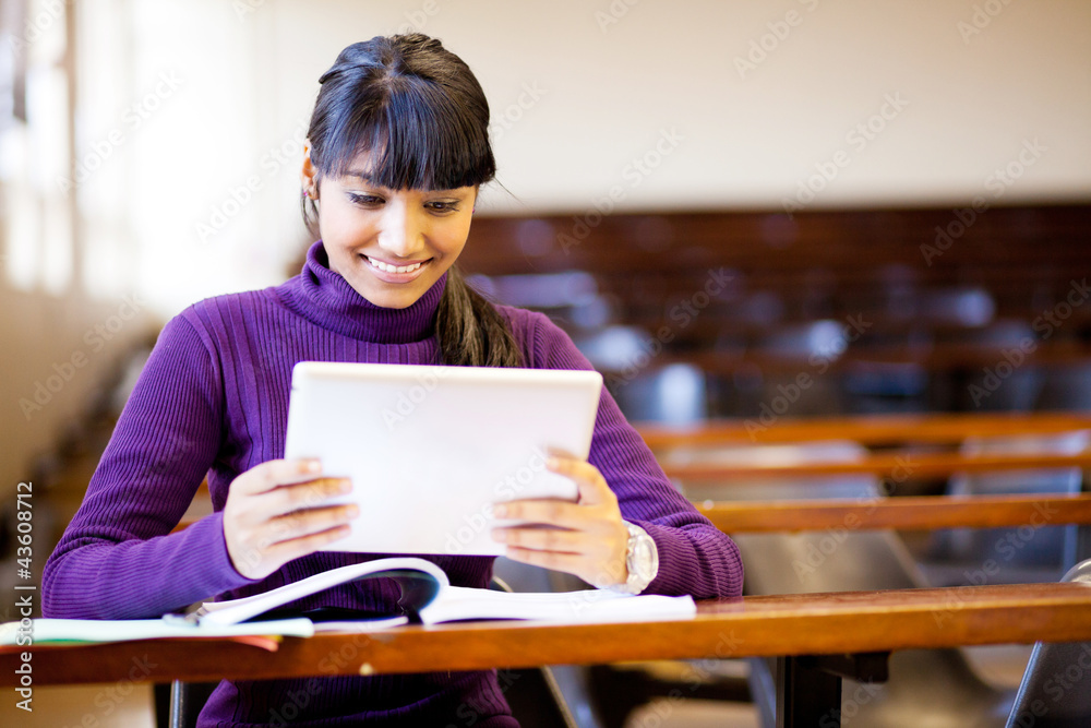 happy female indian college student using tablet computer happy female indian college student using tablet computer