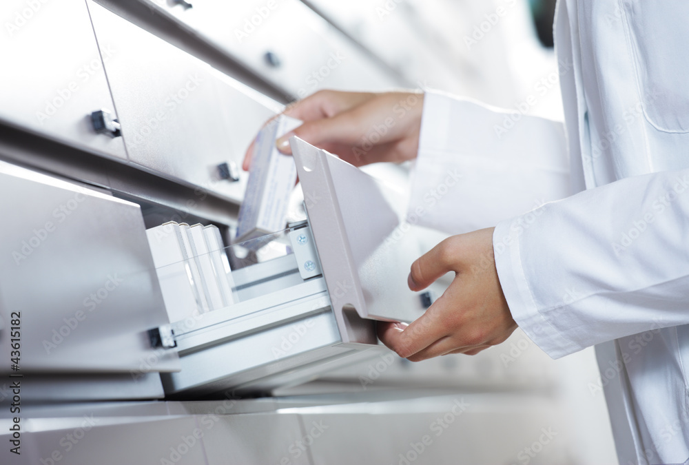 Pharmacist reaching for medicine