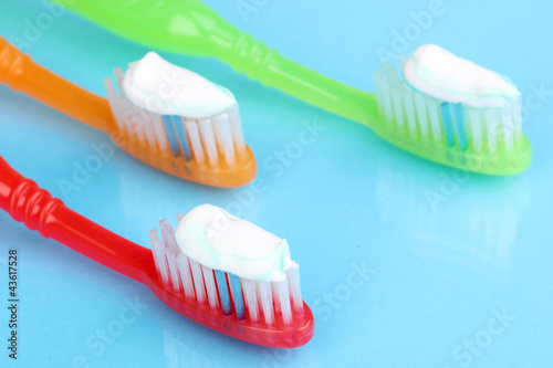 Toothbrushes with paste on blue background