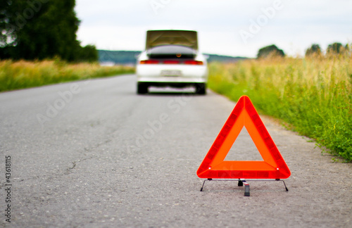 Red warning triangle with a broken down car