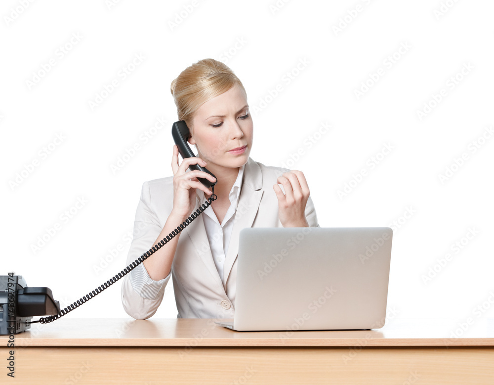 Young businesswoman sitting at a desk and holding phone Young businesswoman sitting at a desk and holding phone