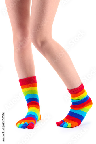 female legs in colorful striped socks isolated on white