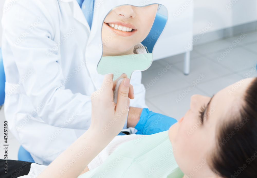 The patient admires her smile looking at the mirror The patient admires her smile looking at the mirror