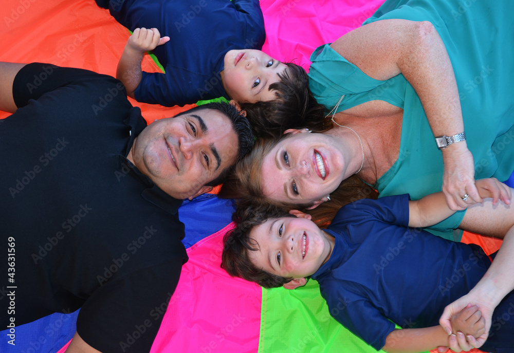 A family posing on the ground on colorful background