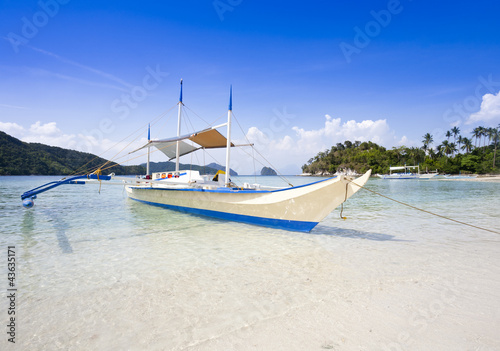 banca boat moored at tropical beach