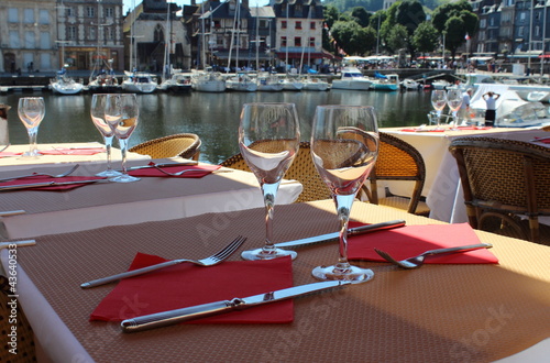 Table sur la terrasse de restaurant français avec vue sur le port  d' Honfleur photo