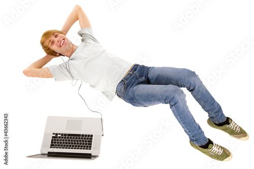 teenage boy with laptop lying down photo