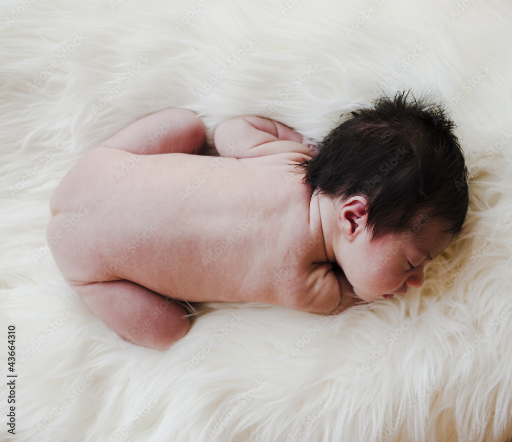 Baby newborn naked on a white carpet Baby newborn naked on a white carpet