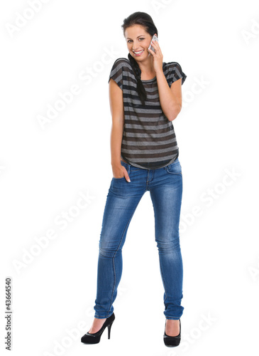 Full length portrait of smiling girl speaking mobile phone