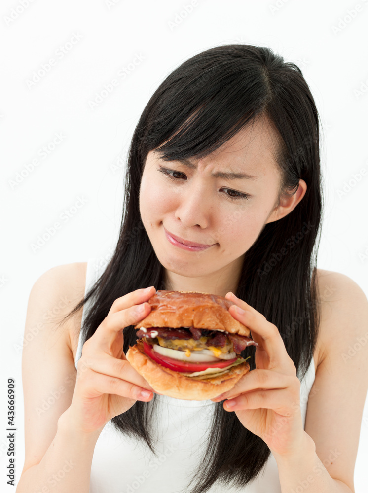 ハンバーガーを食べようとして考える女の子