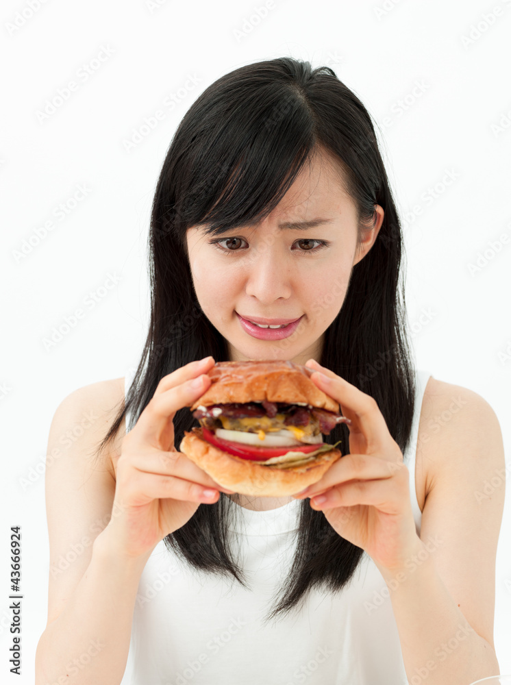 ハンバーガーを食べようとして考える女の子