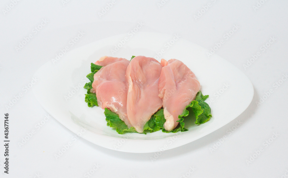 A pair of skinless chicken breasts on a white dish A pair of skinless chicken breasts on a white dish